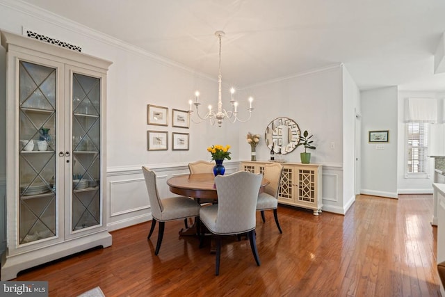 230 Carriage Chase Cir, Warrenton, VA 20186 - dining space featuring a chandelier, hardwood / wood-style flooring, wainscoting, crown molding, and a decorative wall