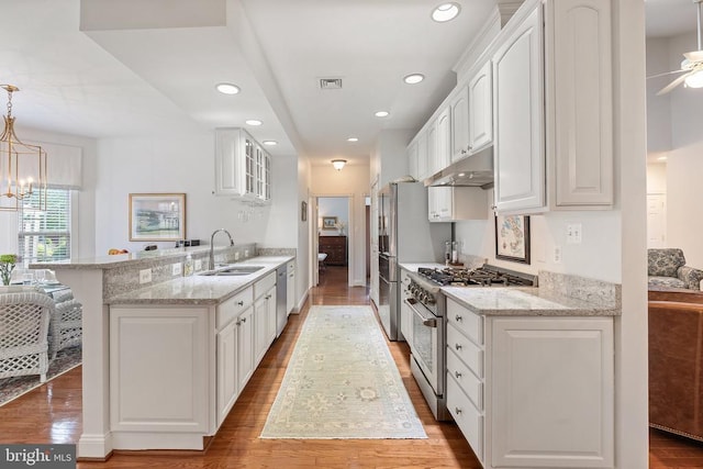 230 Carriage Chase Cir, Warrenton, VA 20186 - kitchen with appliances with stainless steel finishes, a sink, under cabinet range hood, a peninsula, and white cabinetry