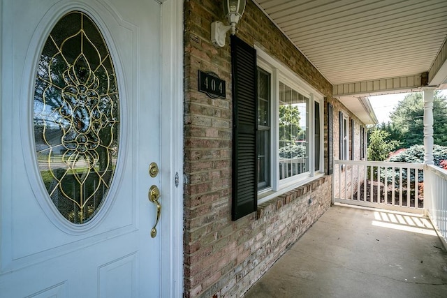 404 3rd St, Grottoes, VA 24441 - doorway to property featuring covered porch and brick siding