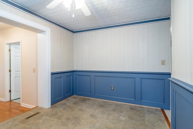 404 3rd St, Grottoes, VA 24441 - spare room featuring a decorative wall, a ceiling fan, and a wainscoted wall