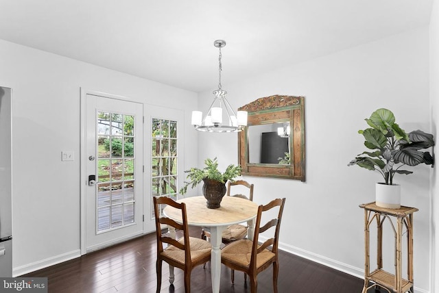 dining room featuring a chandelier, dark wood finished floors, and baseboards
