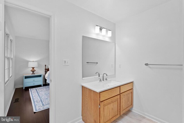 bathroom featuring wood finished floors, vanity, and baseboards