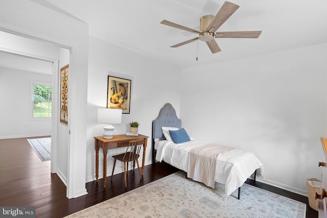 bedroom with wood finished floors, baseboards, and a ceiling fan