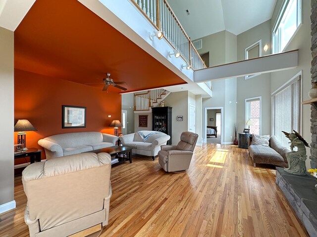 603 Dabneys Rd, Raphine, VA 24472 - living room featuring light wood-type flooring, stairway, a ceiling fan, a high ceiling, and baseboards