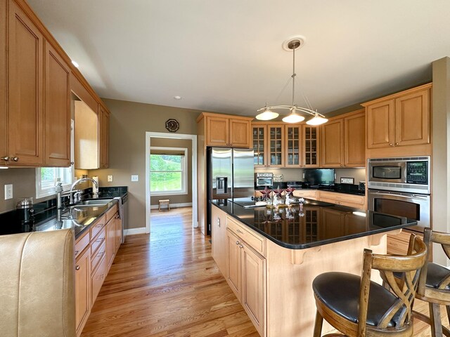 603 Dabneys Rd, Raphine, VA 24472 - kitchen with a center island, glass insert cabinets, a breakfast bar, stainless steel appliances, and light wood-type flooring