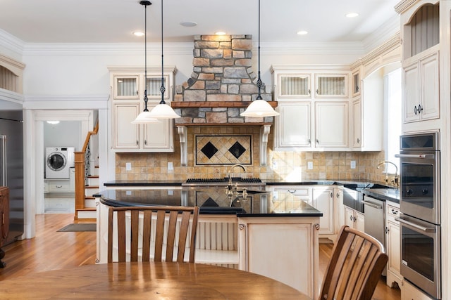 1767 Goose Creek Rd, Waynesboro, VA 22980 - kitchen featuring washer / clothes dryer, stainless steel appliances, a sink, ornamental molding, and an island with sink