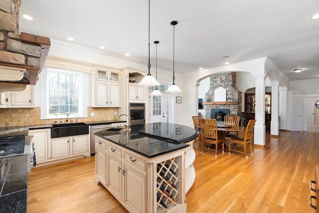 1767 Goose Creek Rd, Waynesboro, VA 22980 - kitchen featuring dark countertops, stainless steel appliances, cream cabinets, a stone fireplace, and a sink