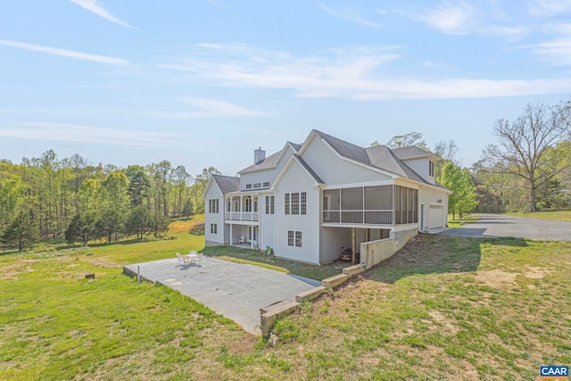 1130 Race Ground Rd, Rochelle, VA 22738 - rear view of property featuring a sunroom, a chimney, a lawn, aphalt driveway, and a patio area