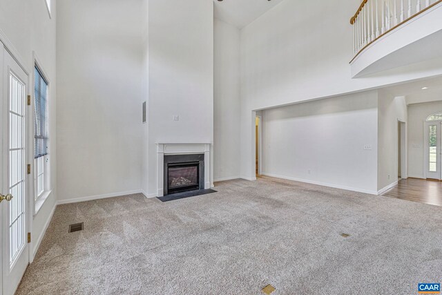 1130 Race Ground Rd, Rochelle, VA 22738 - unfurnished living room featuring baseboards, a high ceiling, visible vents, a fireplace with flush hearth, and carpet floors
