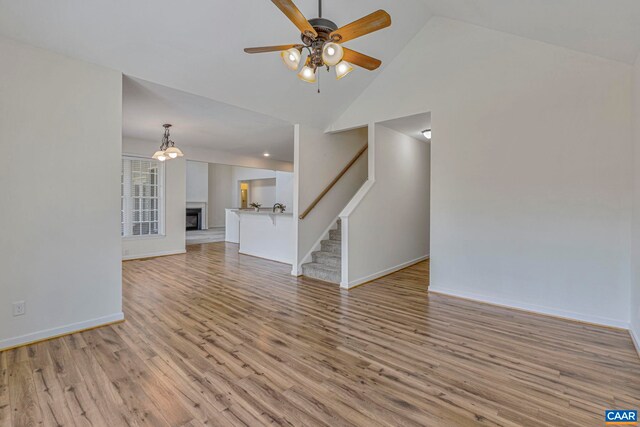 1130 Race Ground Rd, Rochelle, VA 22738 - unfurnished living room featuring baseboards, ceiling fan, stairs, high vaulted ceiling, and light wood-style floors