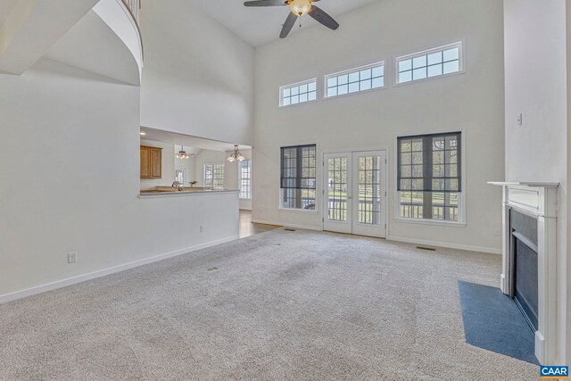 1130 Race Ground Rd, Rochelle, VA 22738 - unfurnished living room with carpet, ceiling fan with notable chandelier, a high ceiling, a fireplace with flush hearth, and baseboards