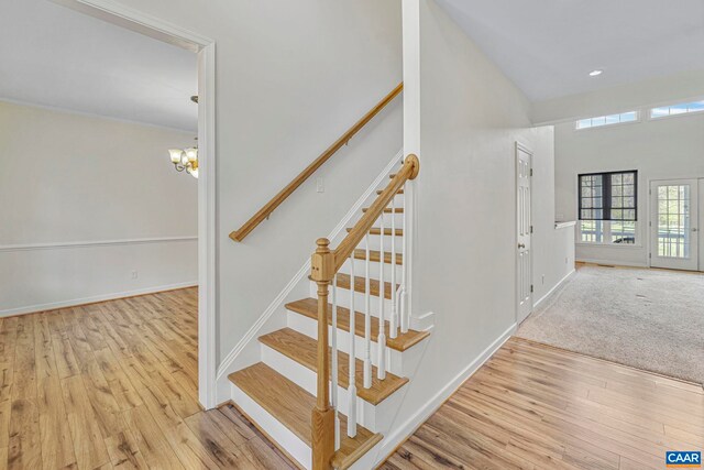 1130 Race Ground Rd, Rochelle, VA 22738 - stairway featuring wood finished floors, baseboards, a high ceiling, and a notable chandelier