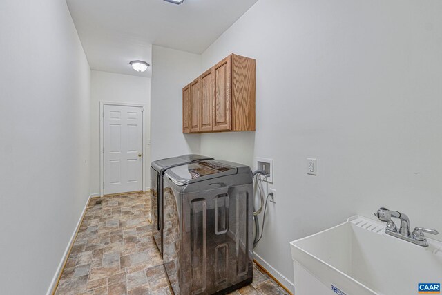 1130 Race Ground Rd, Rochelle, VA 22738 - clothes washing area featuring baseboards, stone finish flooring, a sink, separate washer and dryer, and cabinet space
