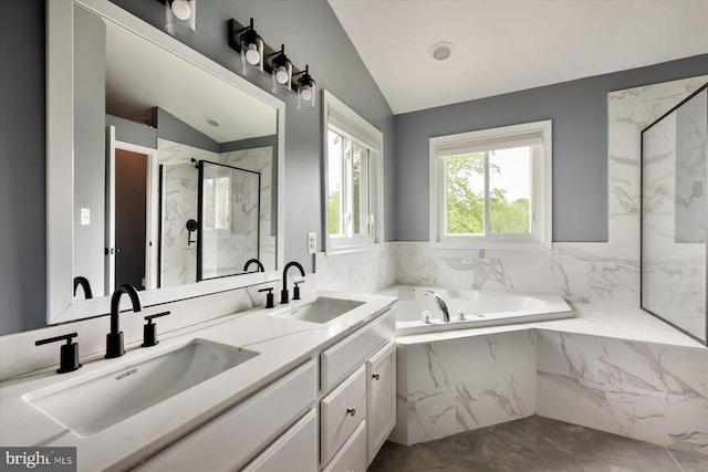 bathroom with a marble finish shower, marble finish floor, lofted ceiling, and a sink