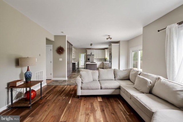 living room with baseboards and dark wood-style floors