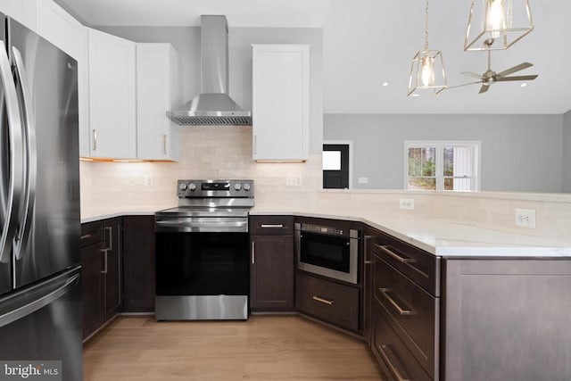 10643 Settle School Rd, Rixeyville, VA 22737 - kitchen with light countertops, stainless steel appliances, white cabinetry, ceiling fan, and wall chimney range hood