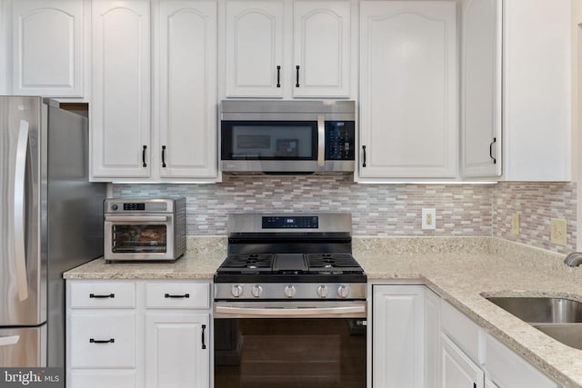 11200 Scottwood Ln N, Fredericksburg, VA 22407 - kitchen with appliances with stainless steel finishes, white cabinets, tasteful backsplash, and light stone counters