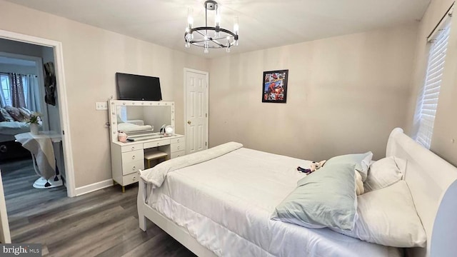 bedroom with dark hardwood / wood-style floors and a notable chandelier