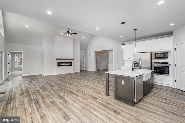 26437 Pennfields Dr, Orange, VA 22960 - kitchen featuring stainless steel appliances, a sink, a ceiling fan, vaulted ceiling, and a large fireplace