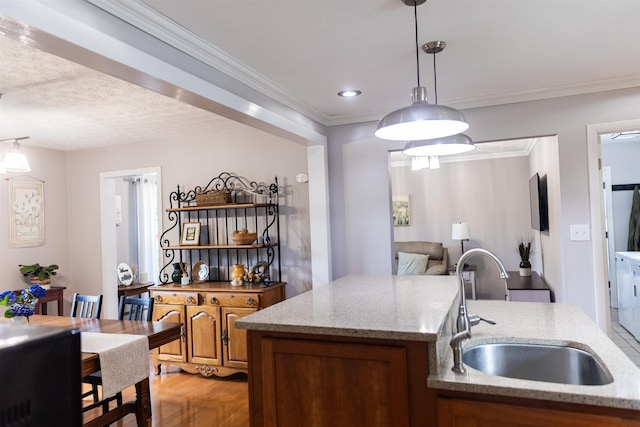 1014 22nd St E, Buena Vista, VA 24416 - kitchen featuring light stone counters, brown cabinetry, hanging light fixtures, light wood-style floors, and crown molding