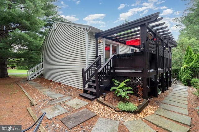  - view of front of home with stairway, a wooden deck, and a pergola