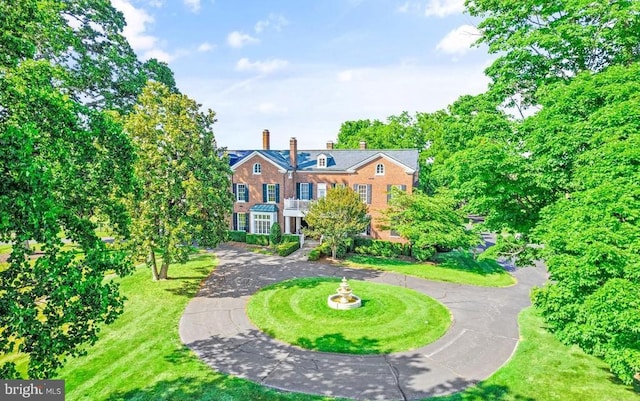  - colonial-style house with curved driveway and a chimney
