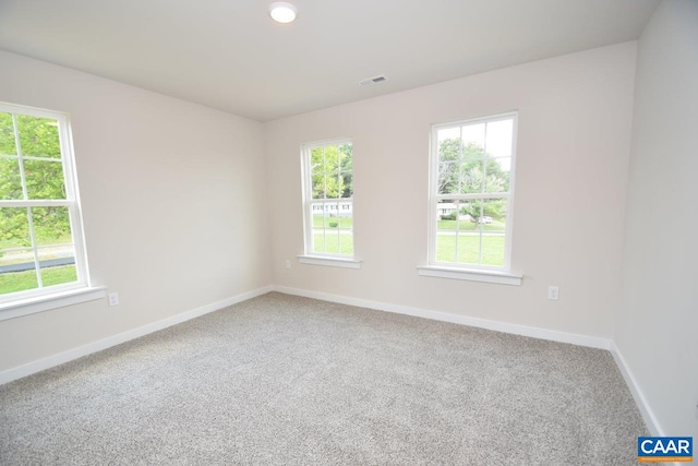 unfurnished room featuring visible vents, baseboards, and a healthy amount of sunlight