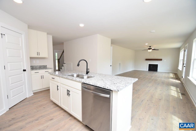 219 Riva Way, Palmyra, VA 22963 - kitchen featuring stainless steel dishwasher, a sink, ceiling fan, a fireplace, and light stone counters