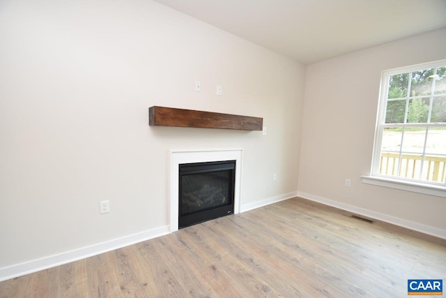 219 Riva Way, Palmyra, VA 22963 - unfurnished living room with a glass covered fireplace, wood finished floors, and baseboards
