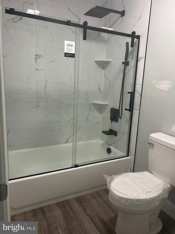  - bathroom with bath / shower combo with glass door and wood finished floors
