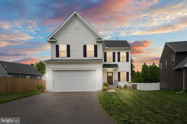 traditional-style house featuring asphalt driveway, an attached garage, and central AC