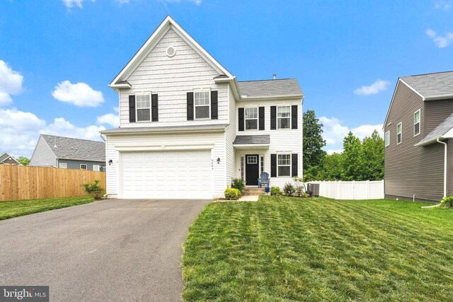 traditional-style house featuring driveway, an attached garage, and central AC unit