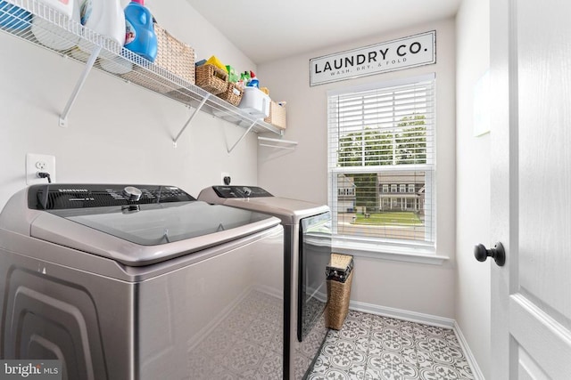 washroom with washer and dryer, baseboards, and light tile patterned floors