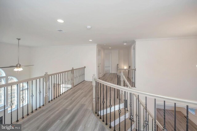  - hallway with light wood-style flooring, an upstairs landing, ornamental molding, and recessed lighting