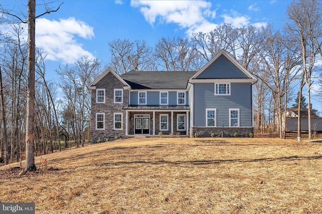  - view of front of house with stone siding, a front lawn, and a porch