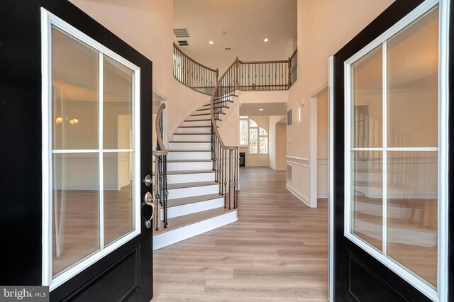  - entrance foyer with light wood finished floors, stairs, a high ceiling, and recessed lighting