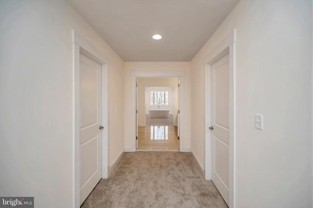  - hallway featuring baseboards, light carpet, and recessed lighting