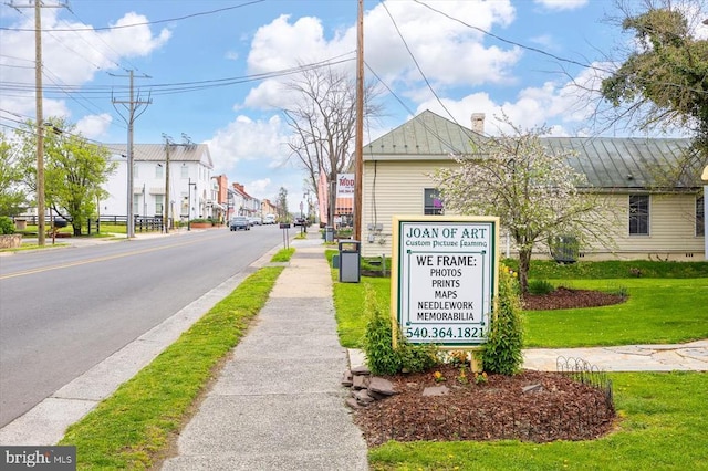 view of asphalt road featuring sidewalks and curbs