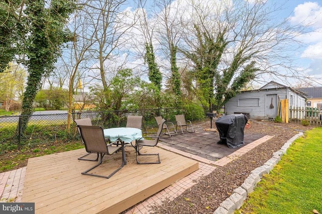 wooden terrace featuring outdoor dining area, a fenced backyard, and an outdoor structure