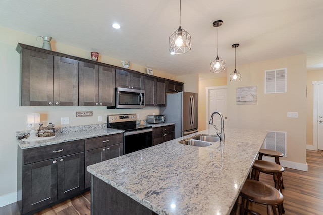 375 Mesa Ct, Broadway, VA 22815 - kitchen featuring appliances with stainless steel finishes, a kitchen breakfast bar, dark wood finished floors, a center island with sink, and dark brown cabinets