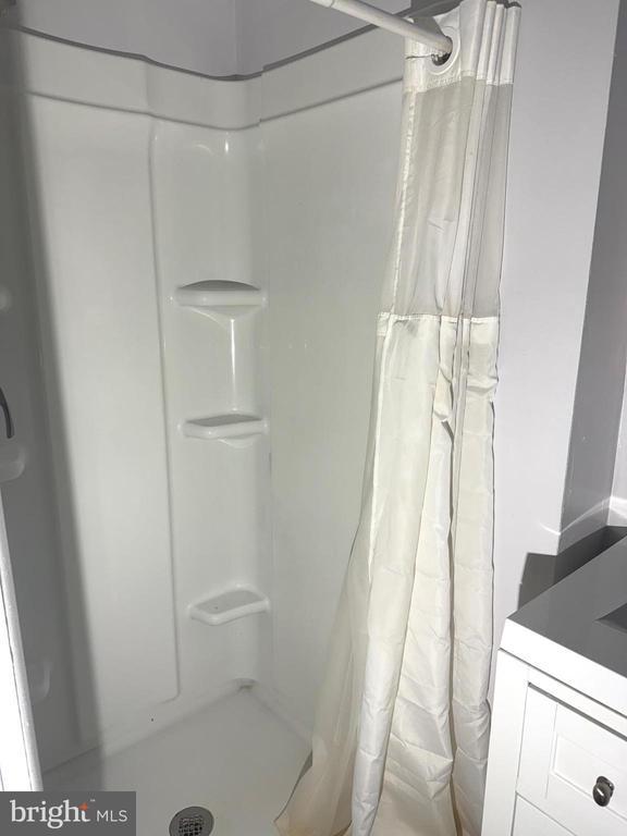  - bathroom with a shower with curtain and vanity