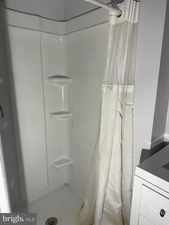  - full bath featuring a shower with shower curtain and vanity