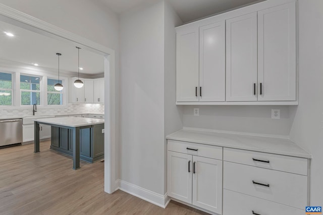 10A Sablewood Dr, Charlottesville, VA 22911 - kitchen featuring stainless steel dishwasher, light wood-style floors, light countertops, white cabinets, and baseboards