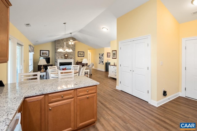 10 Apple Blossom Ct, Nellysford, VA 22958 - kitchen with a peninsula, wood finished floors, visible vents, a fireplace, and vaulted ceiling