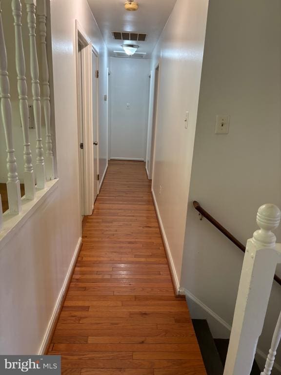  - hallway featuring an upstairs landing, light wood-style flooring, and baseboards