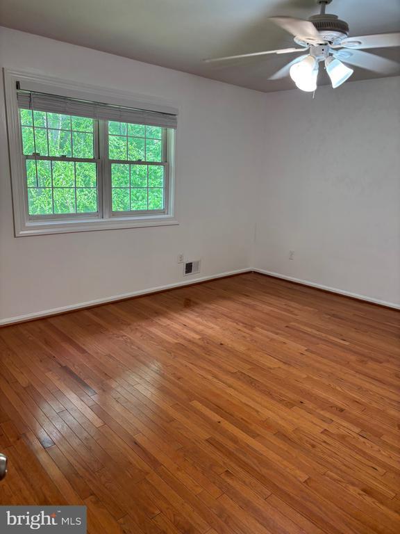  - empty room featuring wood-type flooring, baseboards, and ceiling fan