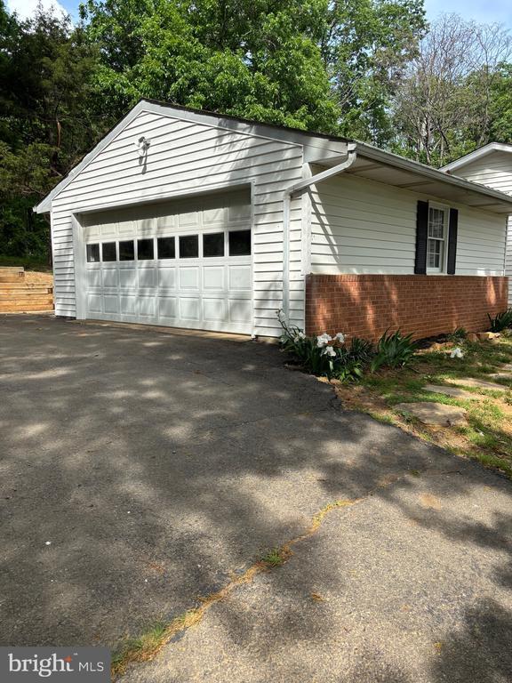  - view of home's exterior featuring a garage and brick siding
