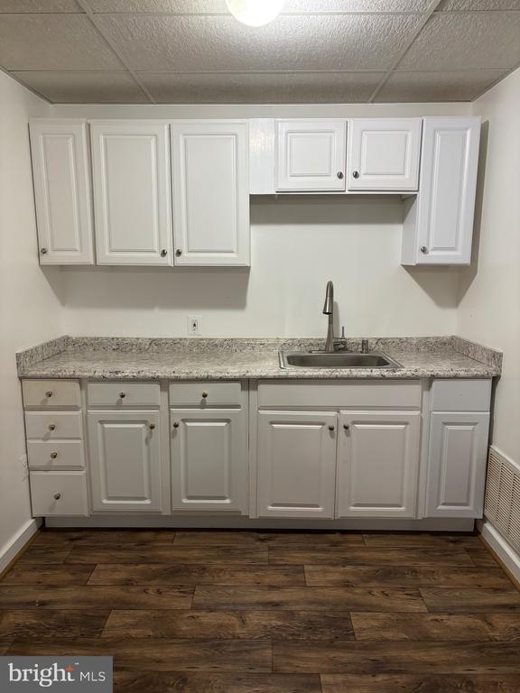  - kitchen with a sink, white cabinets, and light countertops