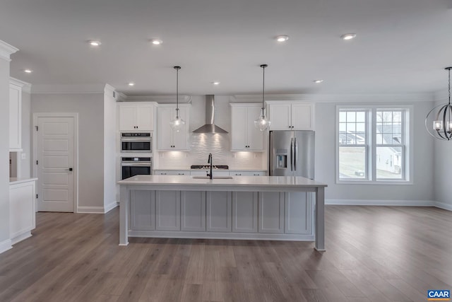 kitchen featuring baseboards, white cabinetry, wall chimney range hood, light countertops, and appliances with stainless steel finishes
