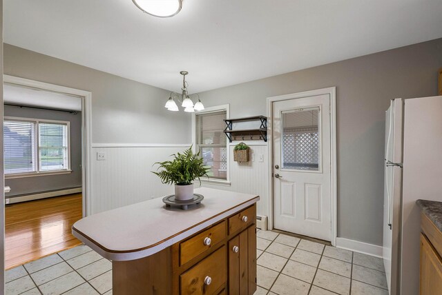 78 Stuart Ave, Stuarts Draft, VA 24477 - kitchen with freestanding refrigerator, baseboard heating, brown cabinets, light tile patterned floors, and a chandelier